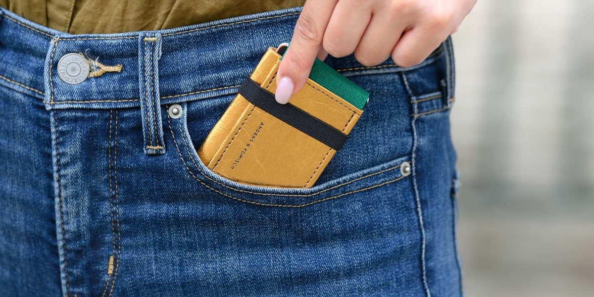 Der A&K MINI Geldbeutel wird in eine Damen Hosentasche vorne gesteckt und soll das Kleinformat einer Kreditkarte zeigen.